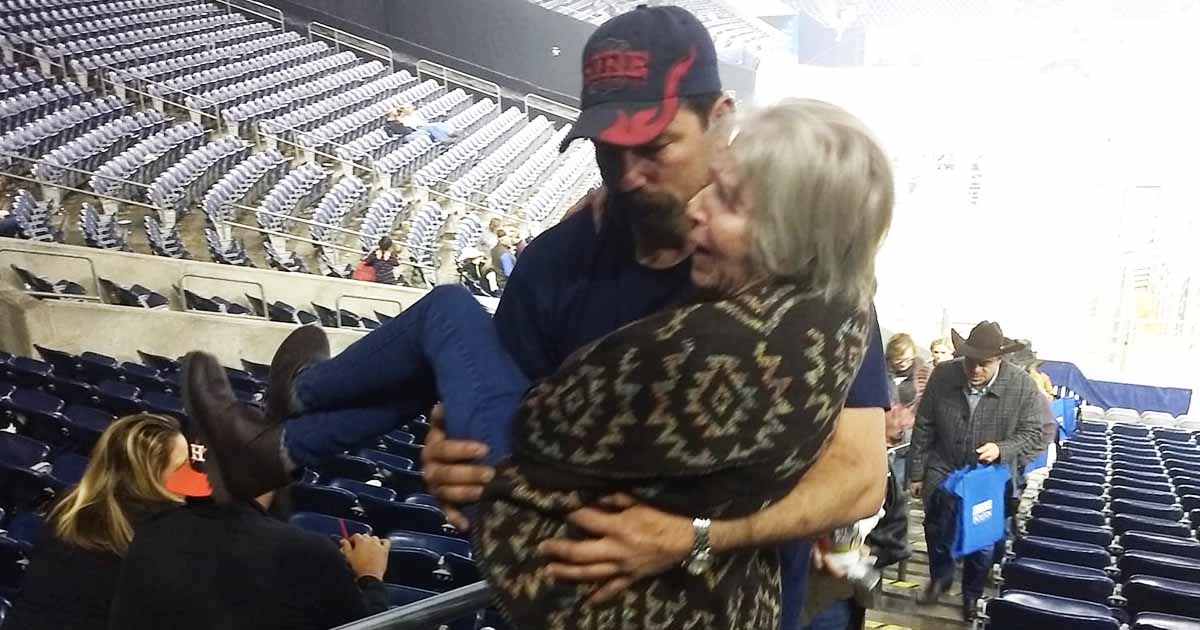 Firefighter Notices Struggling Elderly Woman, Carries Her Up Some Arena Stairs